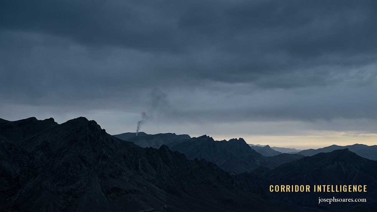 Cold pre-dawn over a stark Iranian mountain desert, a thin plume of smoke on a distant ridge — the ambiguous aftermath of a contested operation